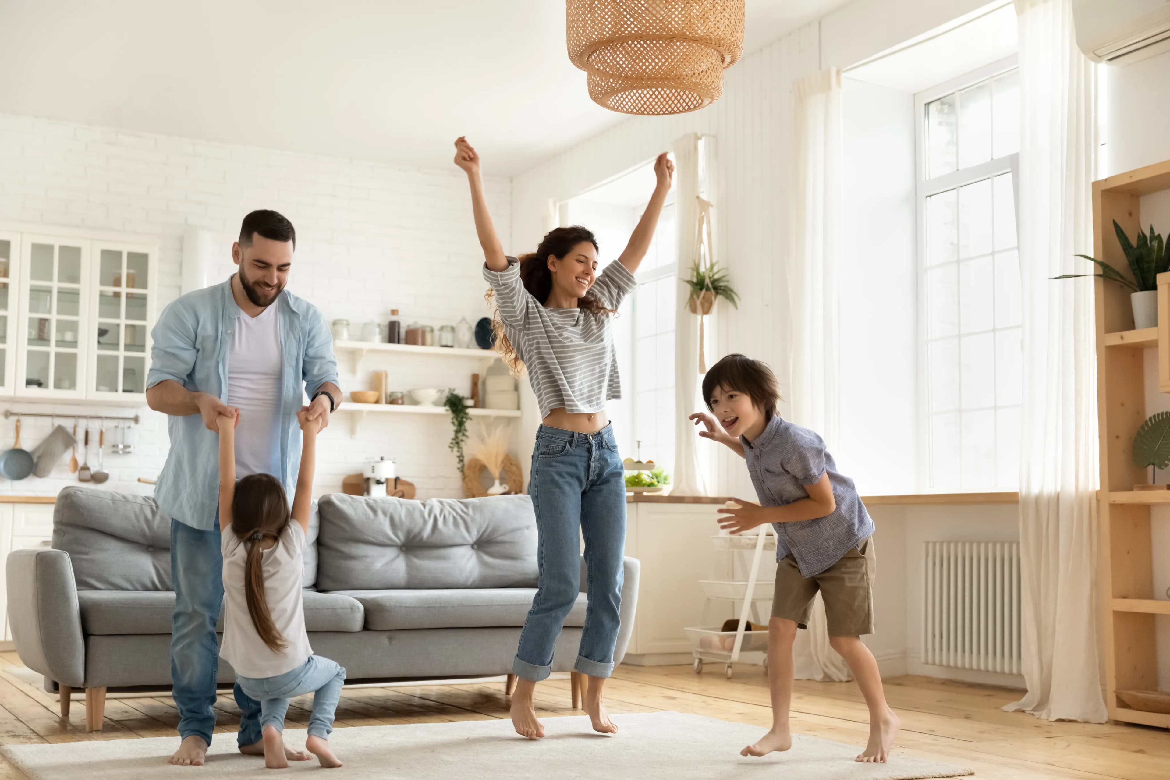 Familie tanzt fröhlich im Wohnzimmer